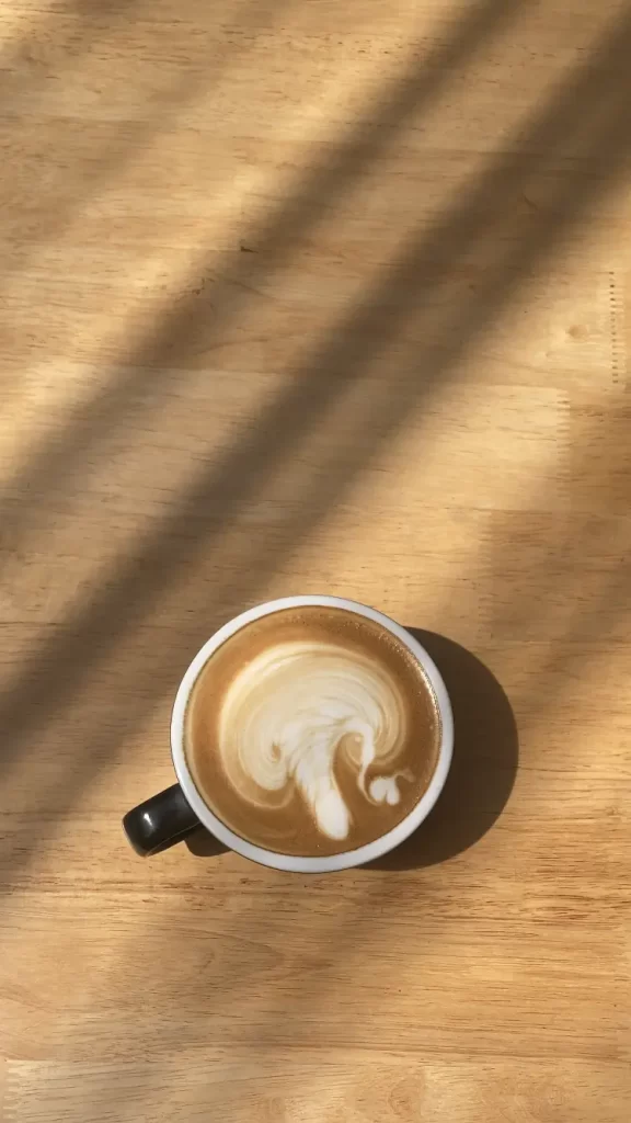 Caramel Macchiato in the sun with some beautiful latte art. The best coffee in Rawai at Poached Rawai Beach, Phuket, Thailand.