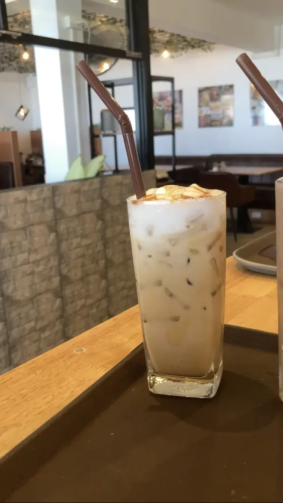 Order's up! An iced caramel macchiato is freshly made and sitting on the counter waiting for service at Poached Breakfast Cafe Rawai Beach, Phuket, Thailand. Best cafe in Nai Harn