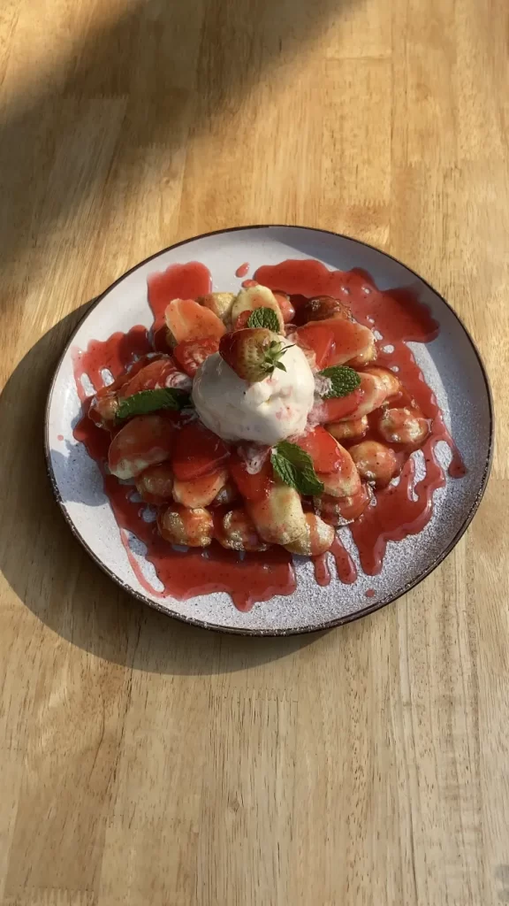 Strawberry Waffles in the sunlight with an ice-cream scoop on top at Poached Rawai Beach, Phuket, Thailand, the best Rawai restaurant.