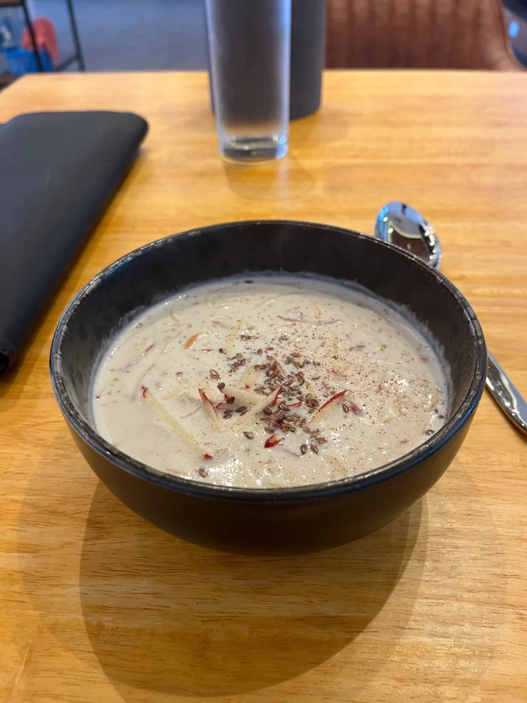 Quinoa power porridge topped with shredded apple on a table at Poached Breakfast Cafe, Rawai, Phuket, Thailand, the best Rawai restaurant