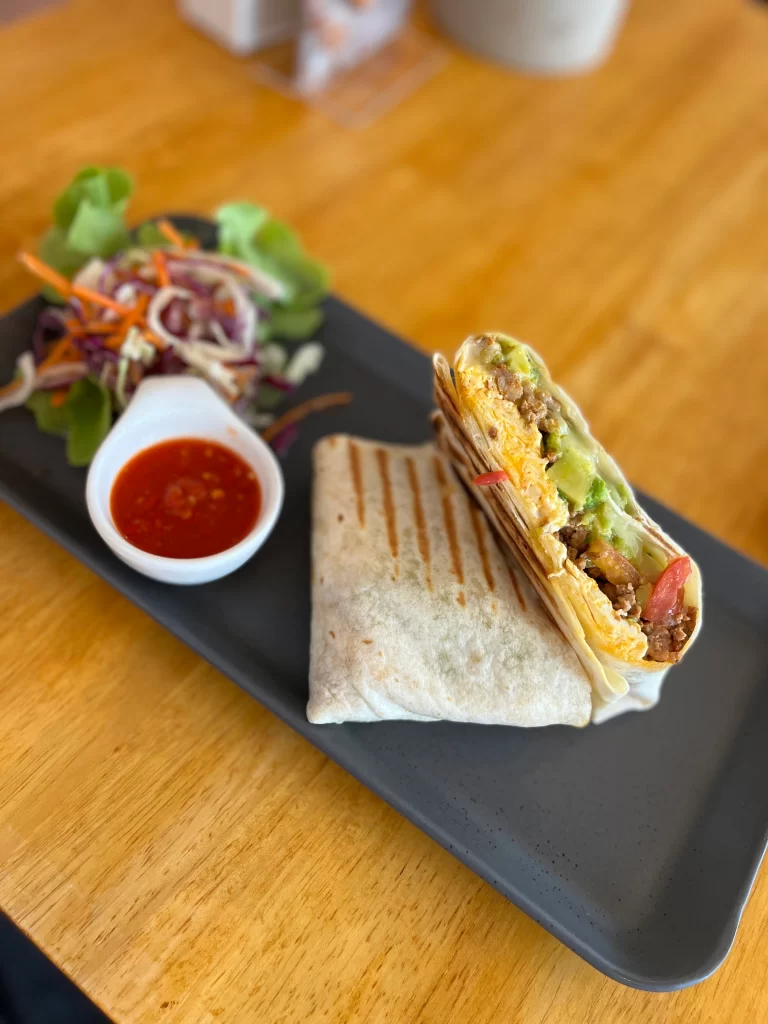 Scrambled egg and sausage breakfast burrito with avocado and zingy salsa. The best all day breakfast at Poached Breakfast Cafe Rawai, Phuket, Thailand.