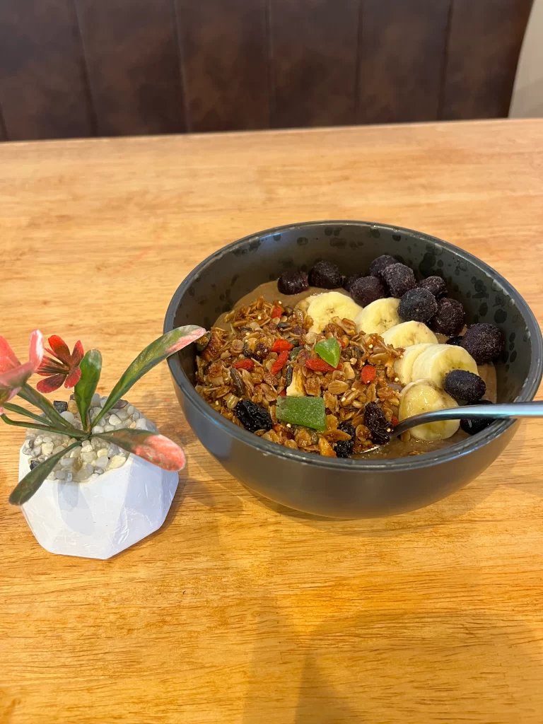 Granola smoothie bowl with banana and frozen berries at Poached Breakfast Cafe Rawai, Phuket, Thailand. Best all day breakfast in Rawai.