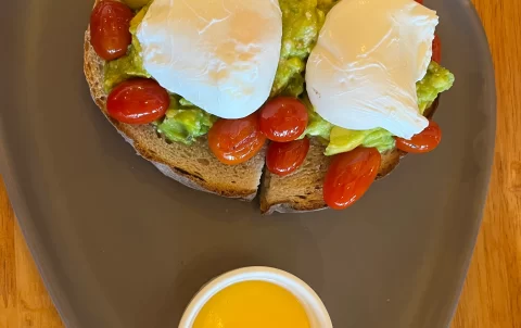 Smashed avocado, roasted tomato and poached eggs on sourdough bread at Poached Breakfast Cafe Rawai, Phuket, Thailand. A good wifi coffee shop in Rawai.