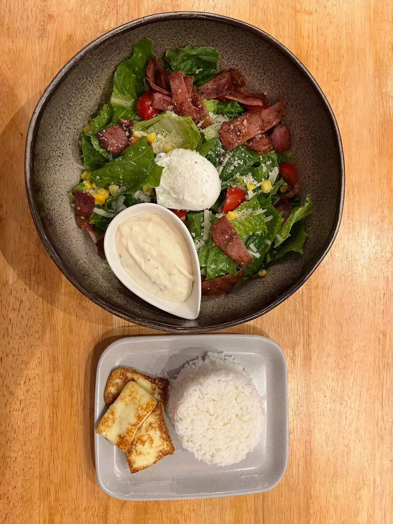 Caesar Salad topped with an egg with a side of rice and halloumi at Poached Breakfast Cafe Rawai, Phuket, Thailand. The best food in Rawai!