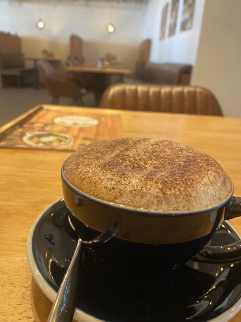 Fluffy cappuccino on a table early in the morning at Poached Breakfast Cafe Rawai, Phuket, Thailand. It's the best iced coffee in Rawai!