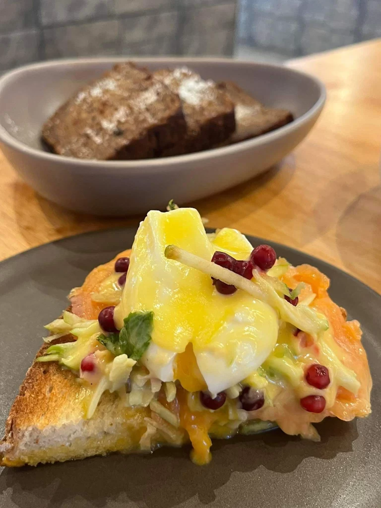 In the foreground you can see eggs benedict and in the background you can see banana bread at the best healthy restaurant in Rawai, Poached Breakfast Cafe, Rawai, Phuket, Thailand