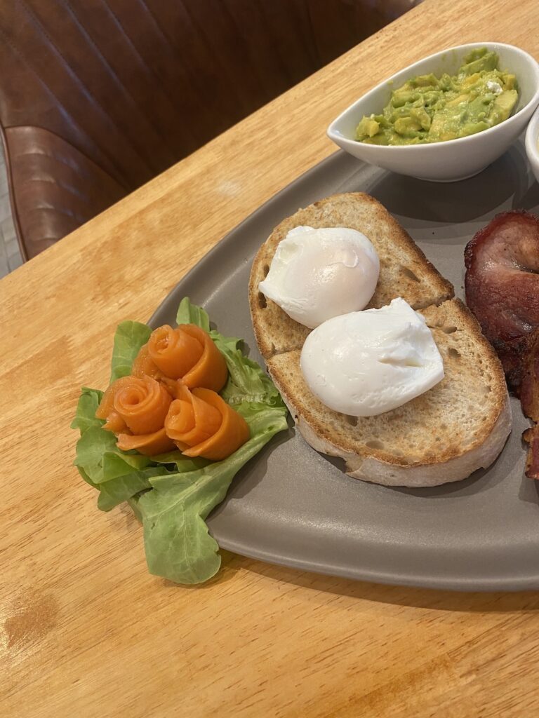 Mixed breakfast with poached eggs, sourdough, smoked salmon, bacon and smashed avocado at one of the best restaurants that deliver in Rawai: Poached Breakfast Cafe Rawai, Phuket, Thailand