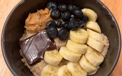 A delicious bowl of museli topped with sliced banana, blueberries, chocolate and peanut butter. Just one of the amazing menu items at the spot with the best cafe menu in Rawai: Poached Breakfast Cafe, Rawai, Phuket, Thailand