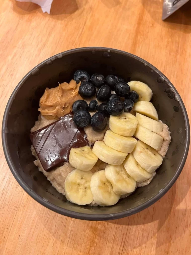 A delicious bowl of museli topped with sliced banana, blueberries, chocolate and peanut butter. Just one of the amazing menu items at the spot with the best cafe menu in Rawai: Poached Breakfast Cafe, Rawai, Phuket, Thailand