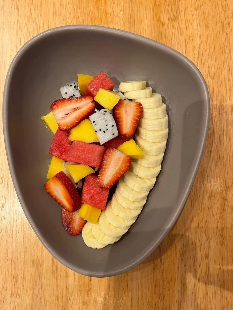 Fresh Fruit Salad in a bowl on a table, Banana, strawberry, mango and dragonfruit at the best cafe in Rawai: Poached Breakfast Cafe Rawai, Phuket, Thailand