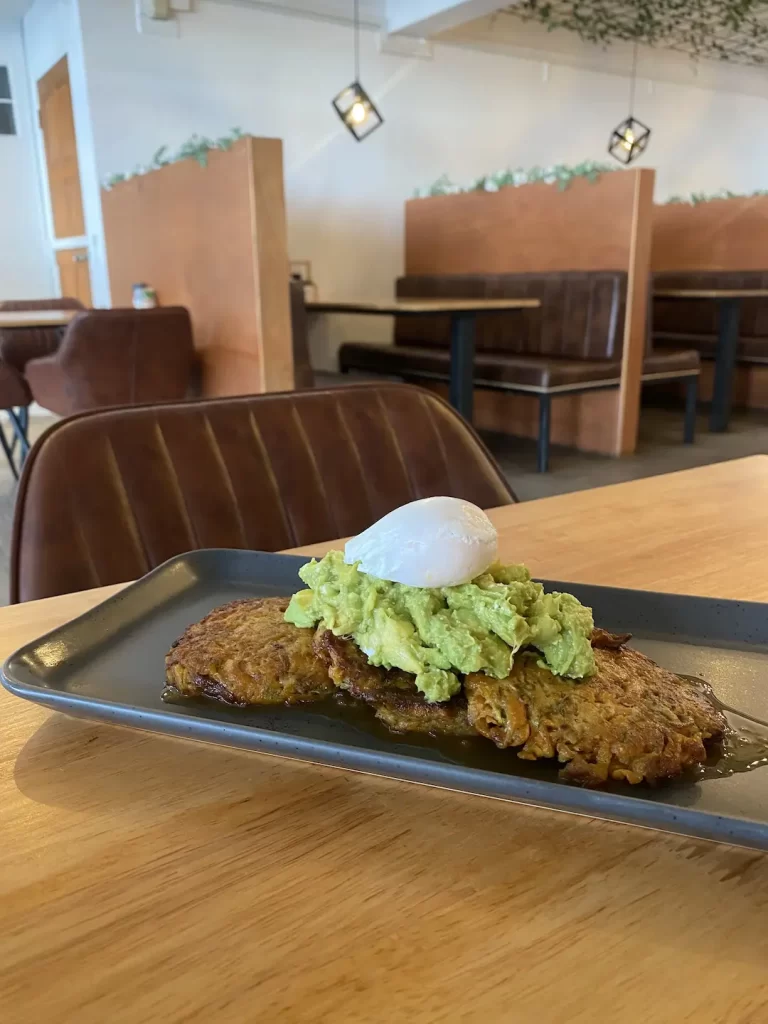 Zucchini fritters with smashed avocado and a poached egg. Only at Poached Breakfast Cafe Rawai, Phuket, Thailand - the best Western breakfast in Rawai!