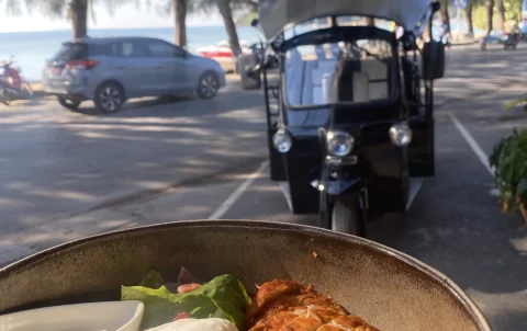 Delicious Cobb Salad with fresh grilled chicken, blue cheese, a poached egg and ranch dressing in front of the Rawai beachfront and a local tuk tuk. All this at the best place to start when you're wanting to explore the walking routes in Rawai: Poached Breakfast Cafe Rawai, Phuket, Thailand