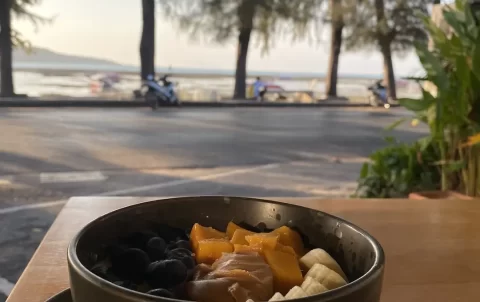 A bowl of porridge on the beach at the cafe that has the best cold brew in Nai Harn: Poached Breakfast Cafe Rawai, Phuket, Thailand