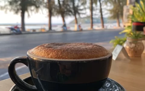 Cappuccino on a table with an ocean view in Rawai at Poached Breakfast Cafe, Rawai, Phuket, Thailand