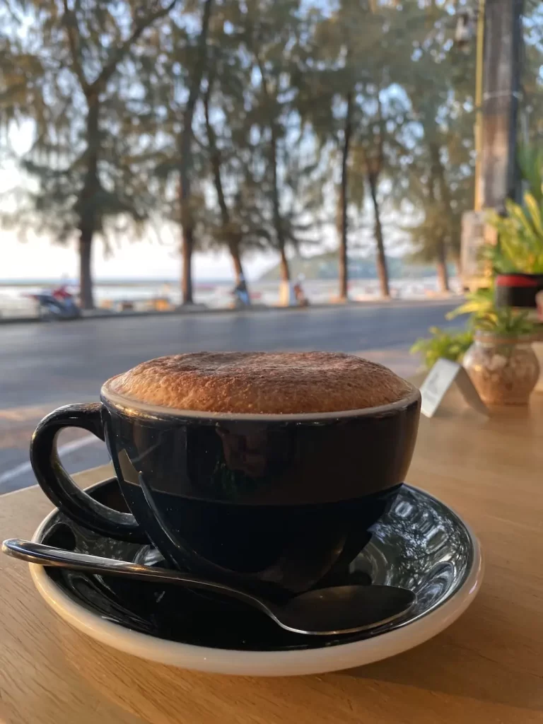 Cappuccino on a table with an ocean view in Rawai at Poached Breakfast Cafe, Rawai, Phuket, Thailand