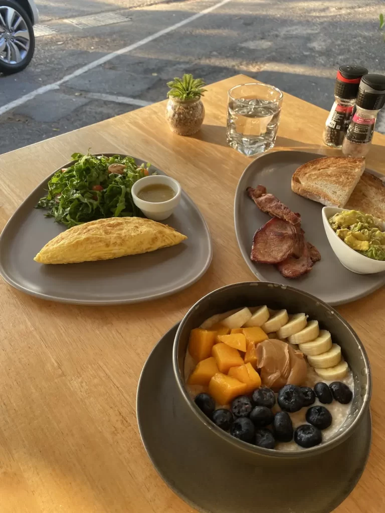 Omelette, salad, bacon, smashed avocado and porridge at the spot with the best cold brew coffee in Nai Harn: Poached Breakfast Cafe Rawai, Phuket, Thailand