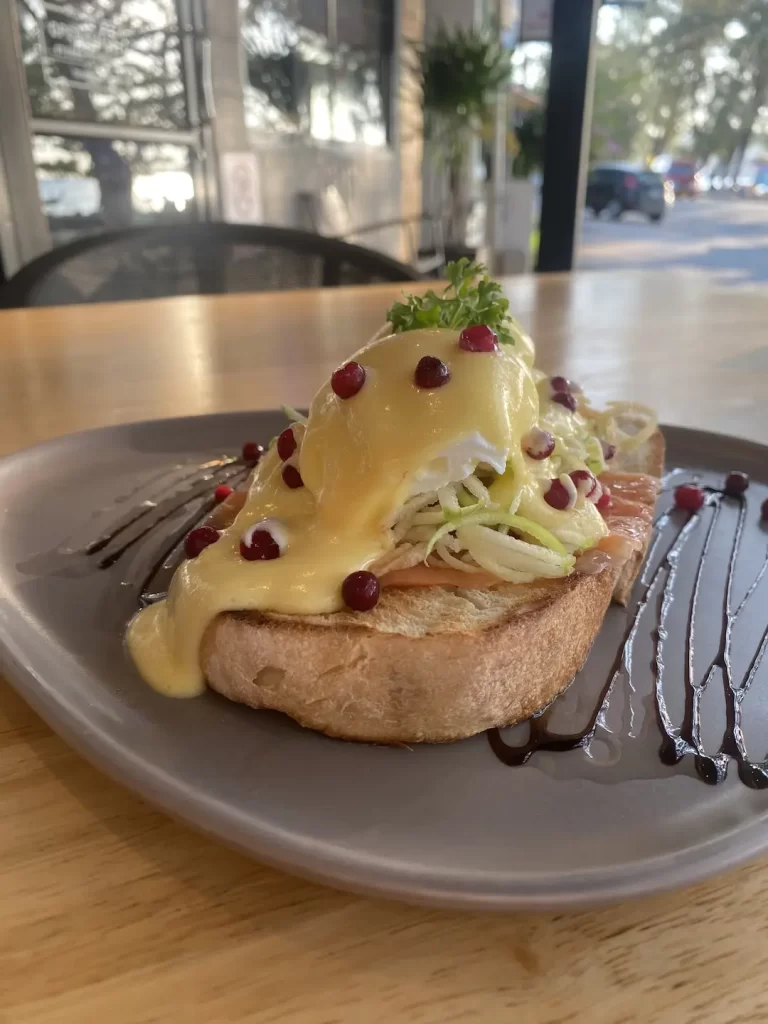 Smoked salmon eggs benedict on a table on top of our outdoor seating in Rawai at Poached Breakfast Cafe Rawai, Phuket, Thailand