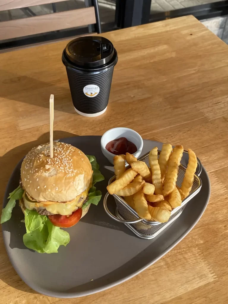 Burger on the table with fries and ketchup at one of the most instagrammable spots near nai harn: Poached Breakfast Cafe Rawai, Phuket, Thailand