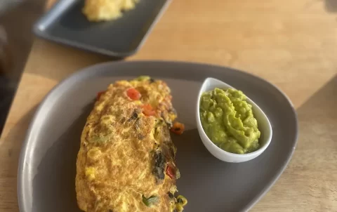 Omelette on the table with smashed avocado at the spot with the best omelette near Nai Harn, Poached Breakfast Cafe Rawai, Phuket, Thailand