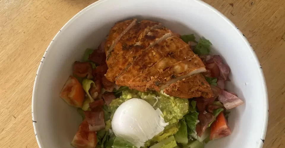 Chicken Cobb salad with avocado, egg and bacon next to a cactus at the top local cafe near Nai Harn: Poached Breakfast Cafe Rawai, Phuket, Thailand