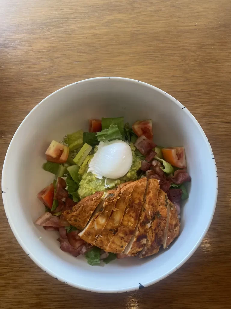 cobb salad on a table with poached egg at the cafe to eat at before you head out on one of the great routes to run in Nai Harn: Poached Breakfast Cafe, Phuket, Thailand