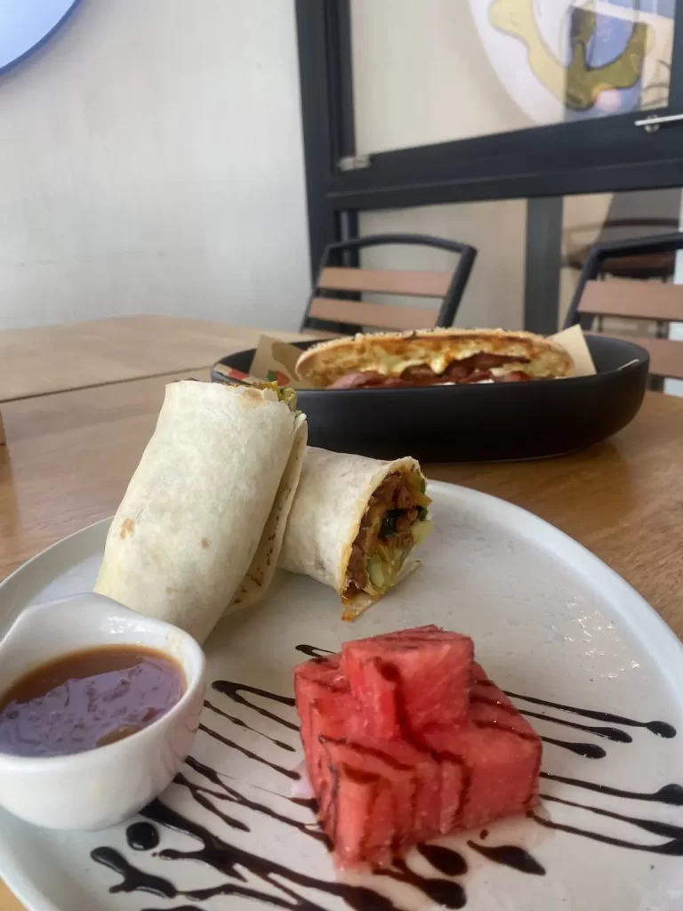 Spicy breakfast burrito and a bacon and egg sandwich at one of the best breakfast bars near Nai Harn, Poached Breakfast Cafe Rawai, Phuket, Thailand