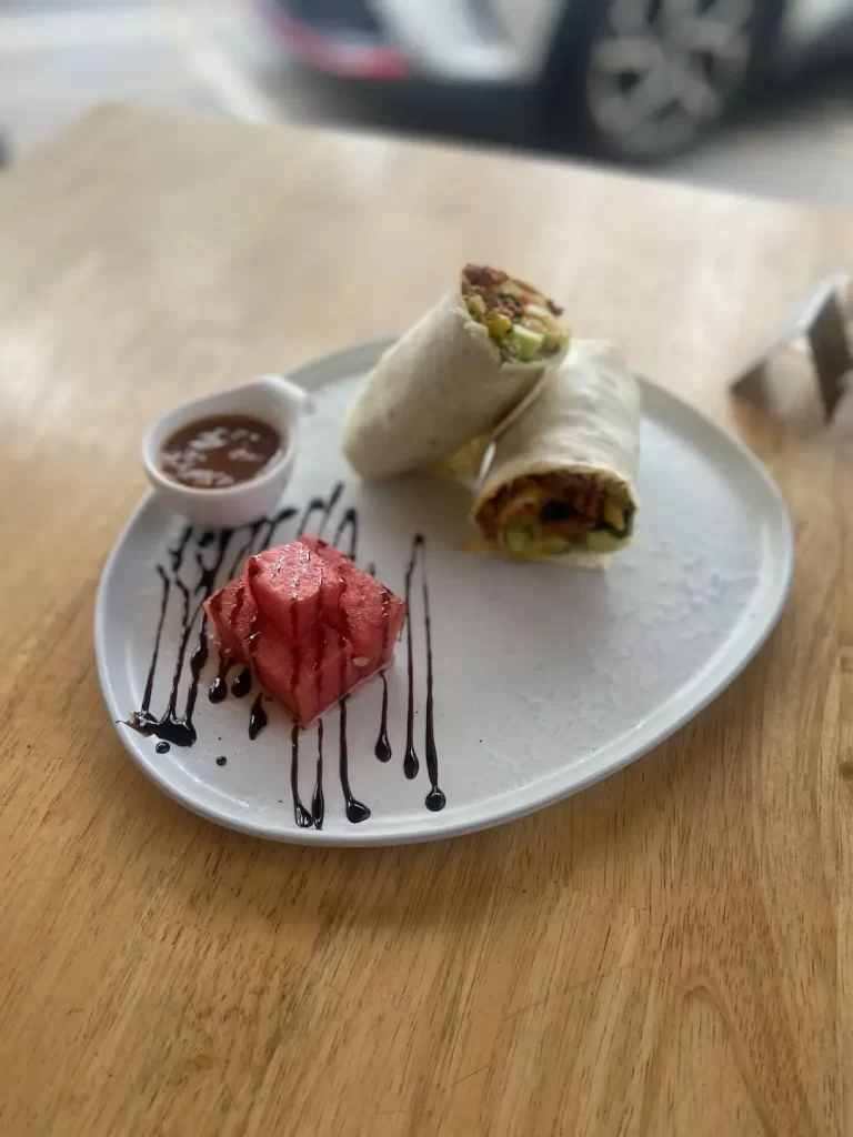 Spicy sausage wrap with watermelon topped with balsamic reduction at the top local cafe near Nai Harn: Poached Breakfast Cafe Rawai, Phuket, Thailand