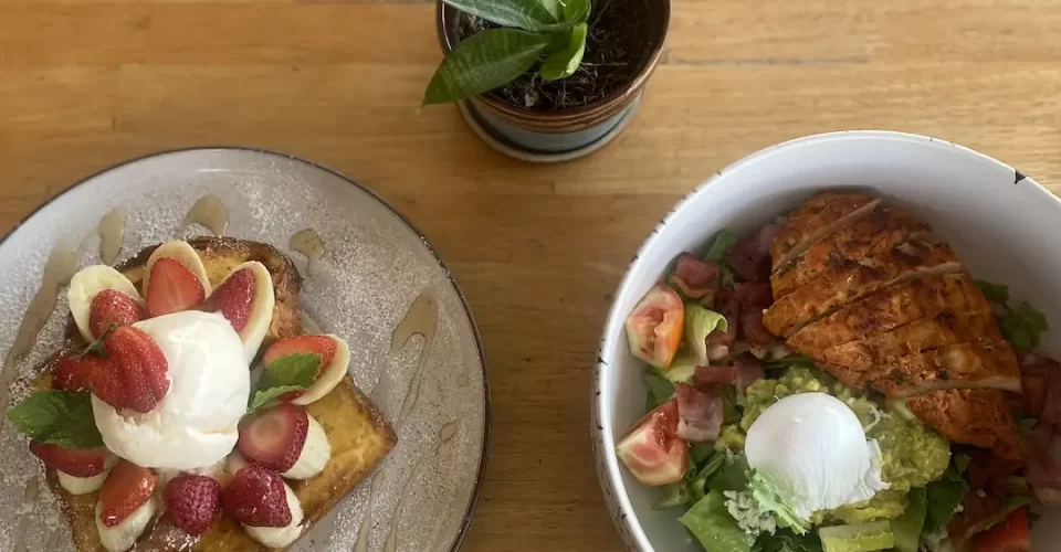 French toast stack with strawberries, banana and an ice cream scoop on the right. A bowl of chicken cobb salad with smashed avocado, poached egg, bacon bits and blue cheese dressing. This is a great place to eat before checking out spots for motorbike hire in Rawai. Only at Poached Breakfast Cafe Rawai, Phuket, Thailand